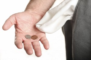 Man with coins in palm and empty pocket