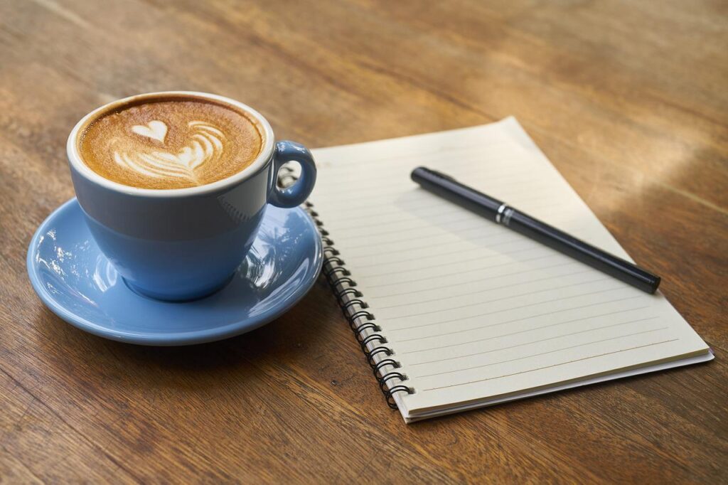 Kahvikuppi, muistivihko ja kynä