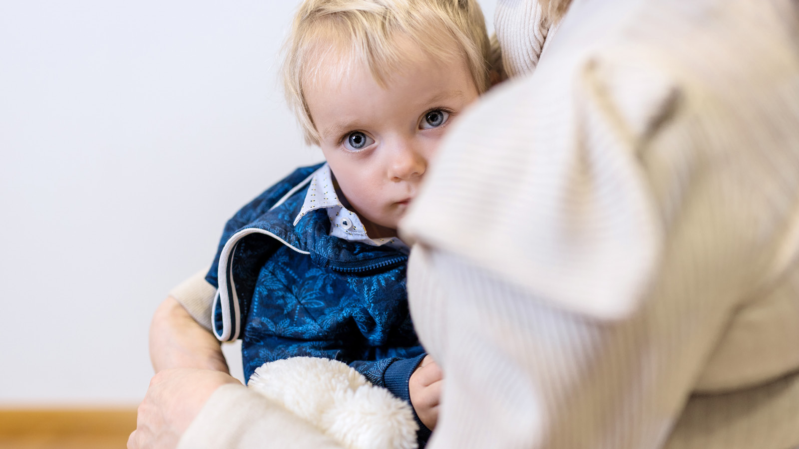 pieni lapsi katsoo naisen olkapään yli